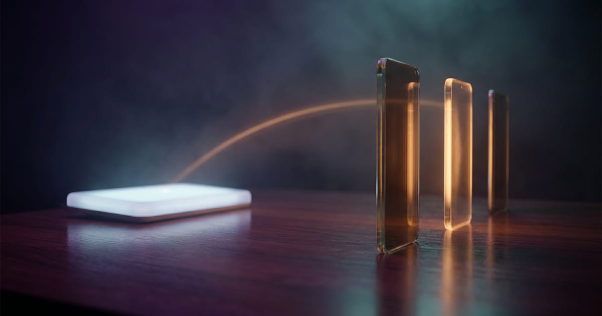 A flat panel of light on a dark table joined by an arc of light to three upright glowing slabs